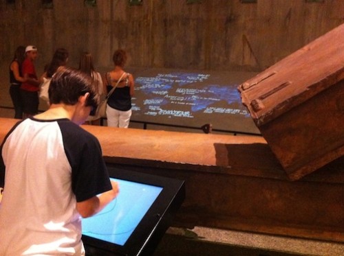 A visitor using a tablet to leave a message, which was then projected onto a museum wall